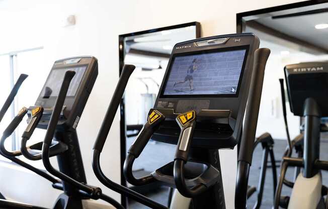 A row of stationary bikes in a gym.