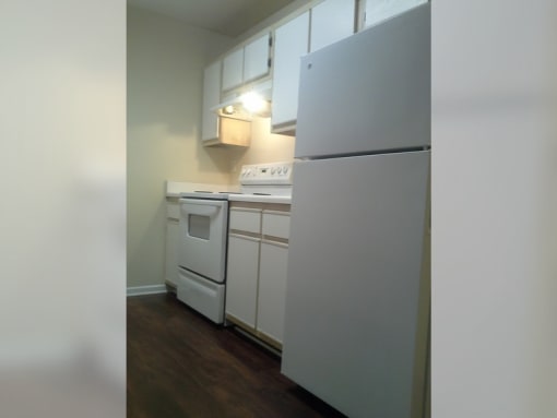 a kitchen with white appliances and white cabinets and a refrigerator