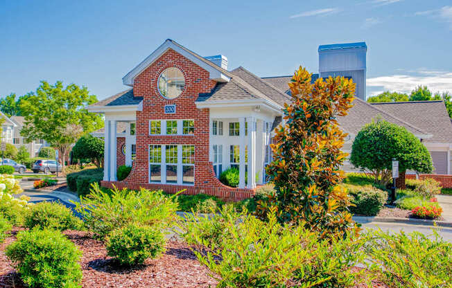 A red brick house with a white trim and a large window.