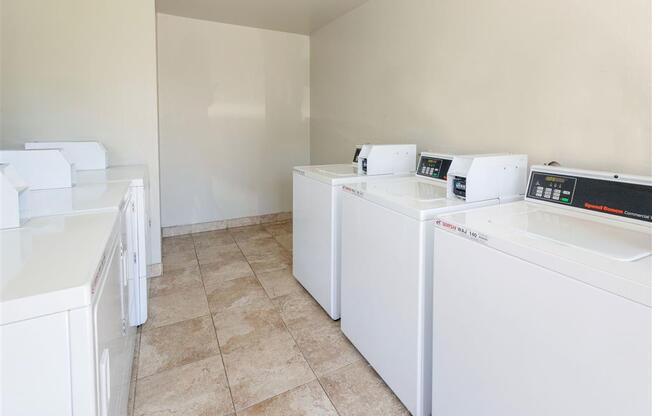 Laundry Center with Machines Next to Folding Counter at Edgewater Isle Apartments & Townhomes, Hanford, CA