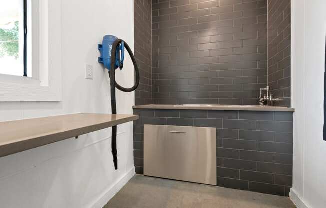 a small laundry room with a dryer and a sink