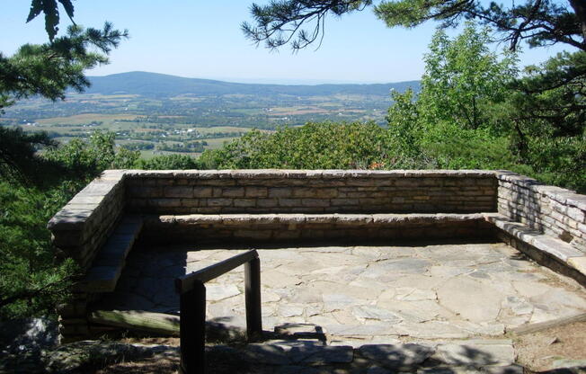 a stone bench with a view of the mountains