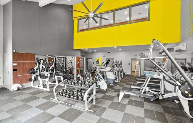 a gym with weights and a ceiling fan