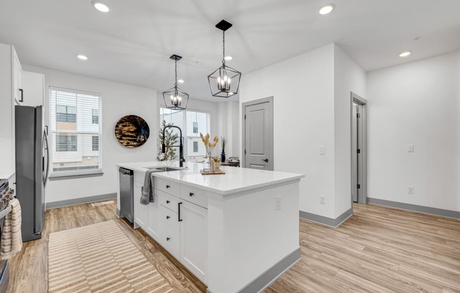 a white kitchen with a large island in the middle at Meridian at CityPlace, Woodbury