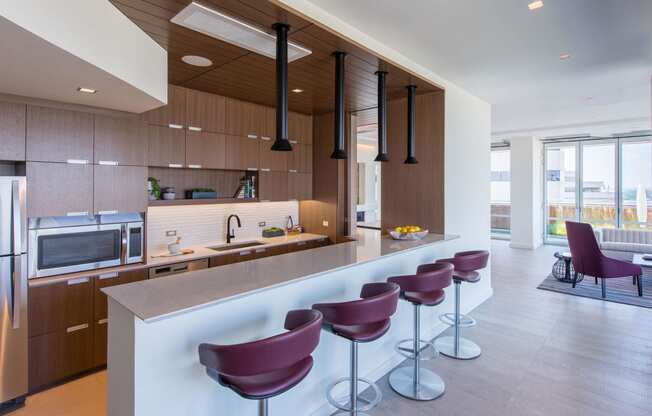 a kitchen with wooden cabinetry and a long island with purple stools