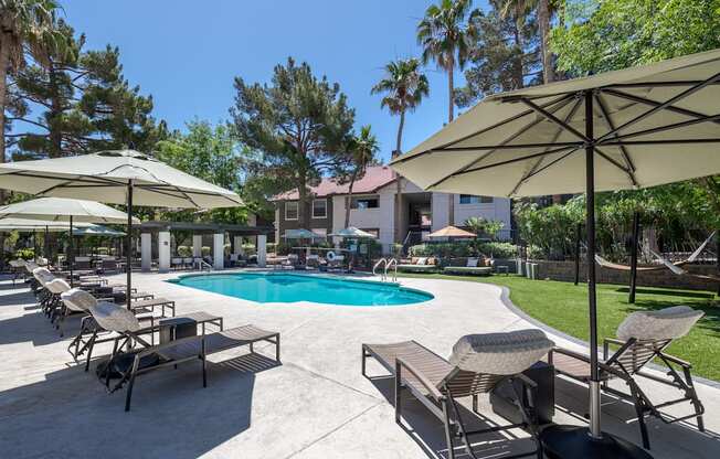 a swimming pool with umbrellas and chairs around it