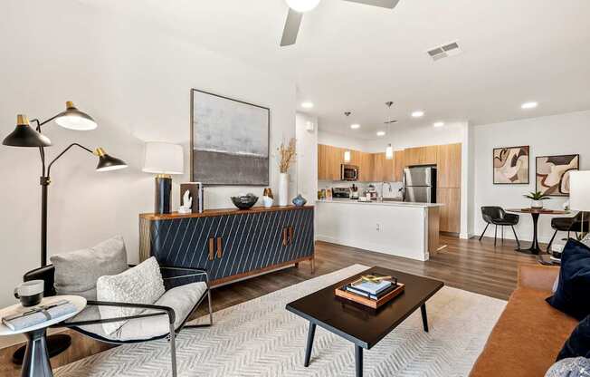 A modern living room with a kitchen in the background.