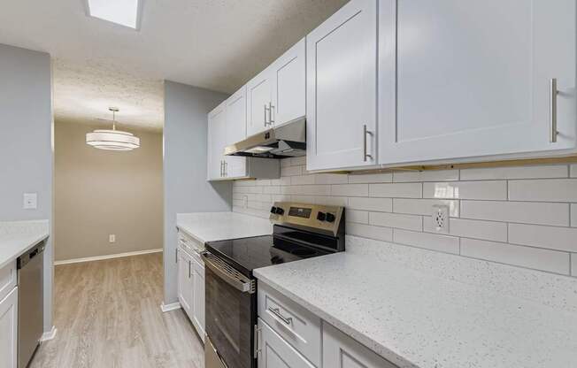 A kitchen with white cabinets and a black stove top oven.