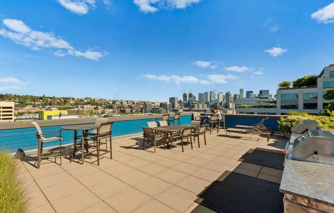 an outdoor terrace with tables and chairs with a city skyline in the background at Dexter Lake Union, Seattle, WA, 98109