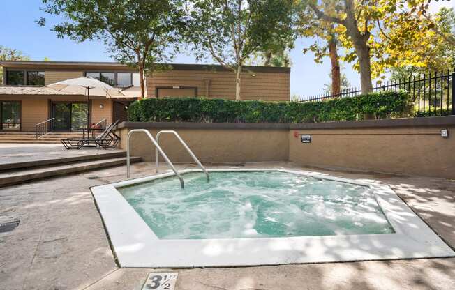 a hot tub in a backyard with a house in the background