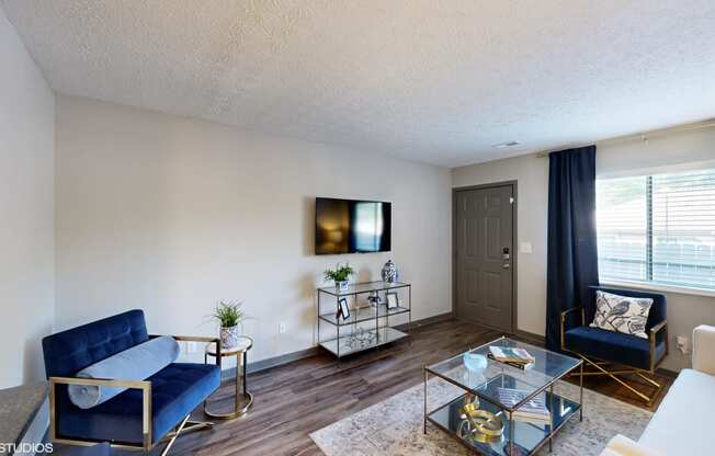 a living room with two blue couches and a glass coffee table