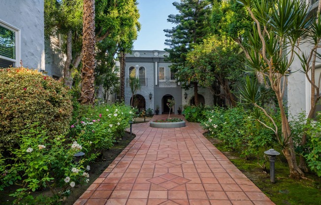 A garden pathway with a white house in the background.