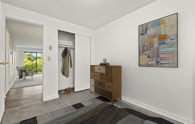 a living room with a dresser and a door to a closet