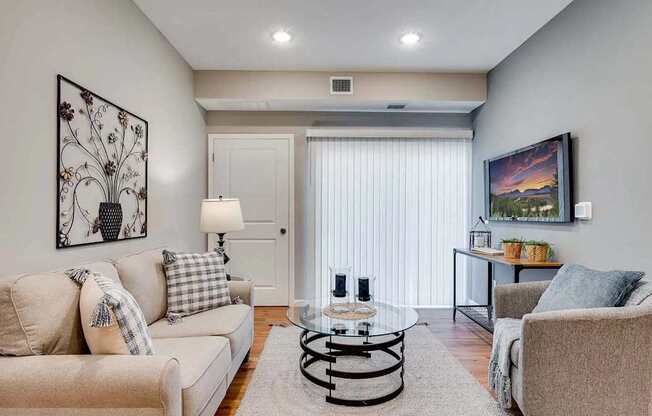 a living room with two couches and a glass coffee table. Circle Pines, MN Lexington Lofts