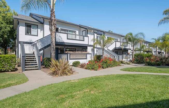 A modern apartment complex with a well-maintained lawn and landscaping.