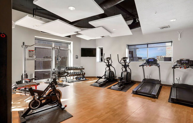 a workout room with treadmills and other exercise equipment