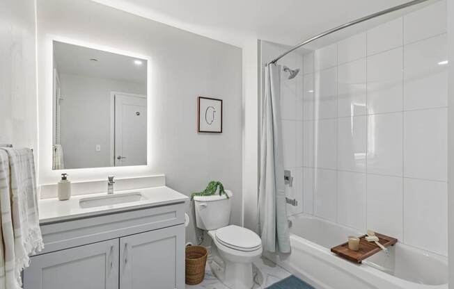 A white bathroom with a toilet, sink, and bathtub.