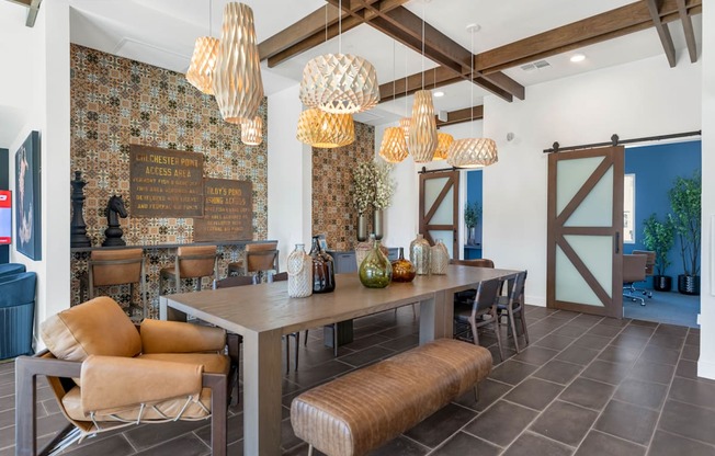 A dining room with a table and chairs and a wallpapered wall.