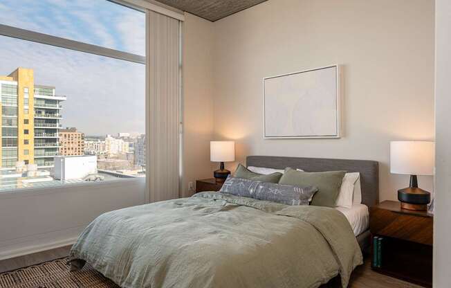 A bedroom with a large bed and a view of the city.