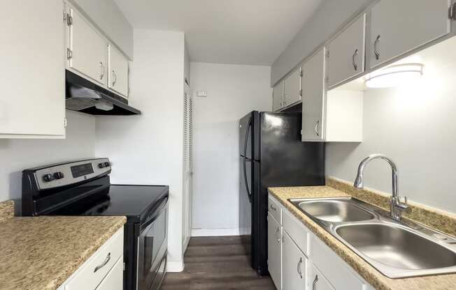 a kitchen with white cabinets and black appliances and granite counter tops