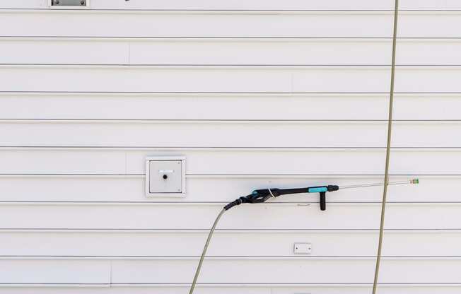 a hose plugged into the side of a garage door