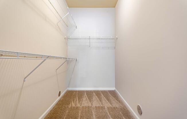 a spacious walk in closet with a mirrored wall and a hanging rack