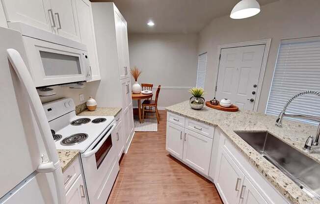A kitchen with white appliances and cabinets.