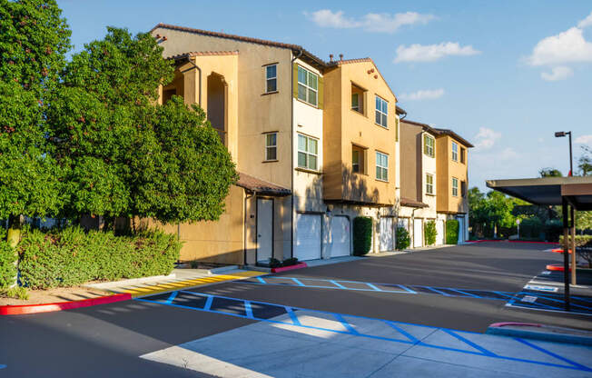 an empty parking lot in front of a row of apartment buildings