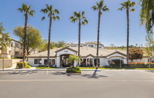 A building with palm trees in front of it.