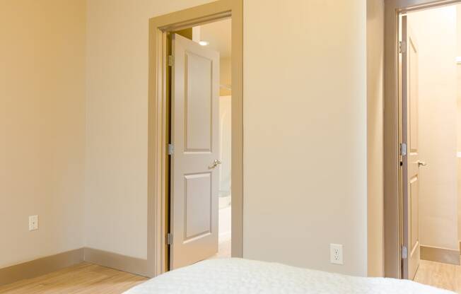 a bedroom with a white door and a white bed