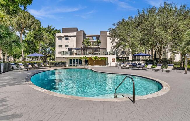 A swimming pool surrounded by a brick patio and lounge chairs.