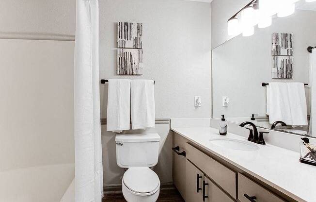A white toilet sits in a bathroom next to a sink.