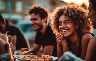 a group of people eating pizza at a table