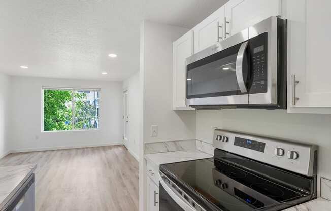 a kitchen with white cabinets and a black stove top oven