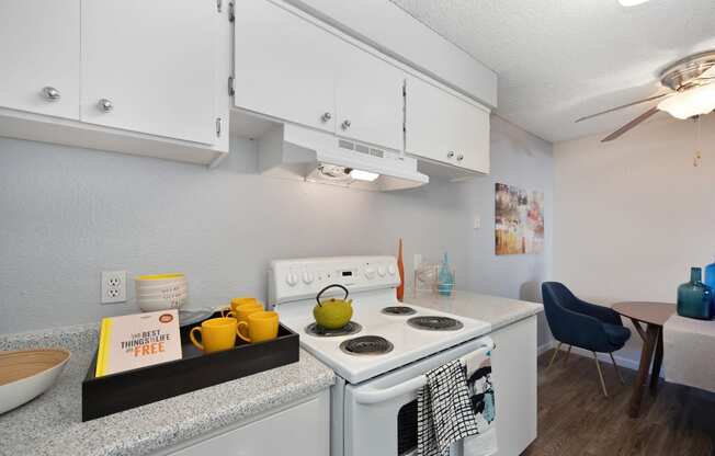 Kitchen with Stove with light colored Walls, Stove, Hardwood Inspired Floor and White Cabinets at The Renaissance Apartments, Citrus Heights