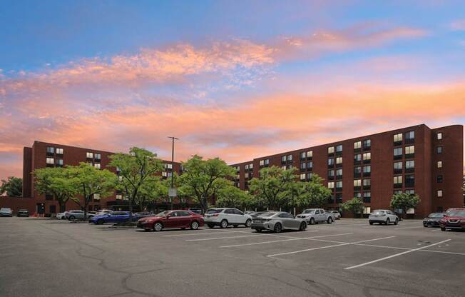A parking lot with cars and a building in the background.