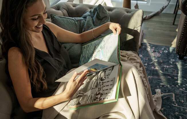 woman reading a book on a couch in pixon living room at Lake Nona Pixon, Orlando, Florida