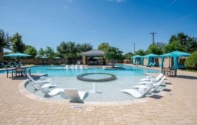 a resort style swimming pool with lounge chairs and umbrellas