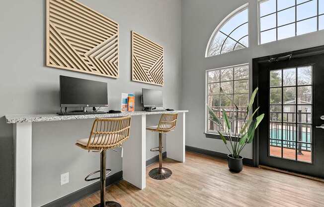 A room with a desk and chairs with a large window.