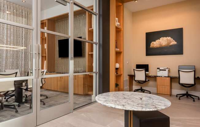 an office with glass doors and a marble table
