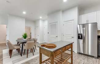 a kitchen with a table and chairs and a refrigerator