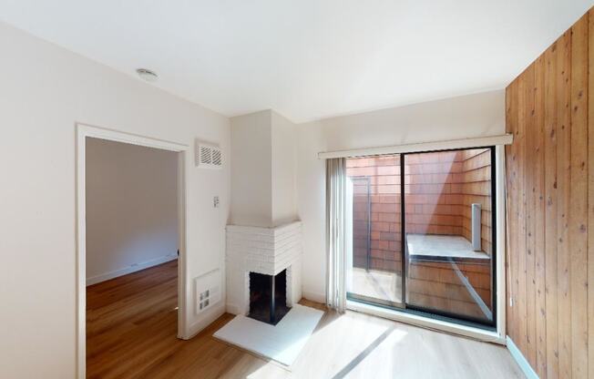 a bedroom with a fireplace and a sliding glass door that leads to a balcony