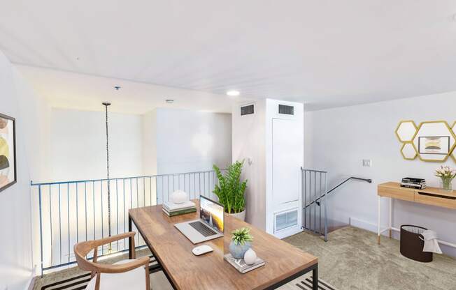 a living room with a wooden table and a railing