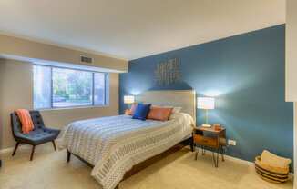 a bedroom with a bed and a chair at Central Park East in Arlington Heights, IL