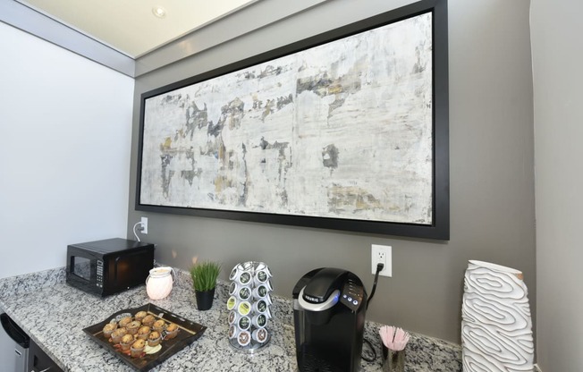 a kitchen with a counter top and a large painting on the wall