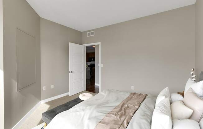 a bedroom with grey walls and white furniture