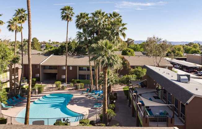 an aerial view of a resort with a swimming pool and palm trees