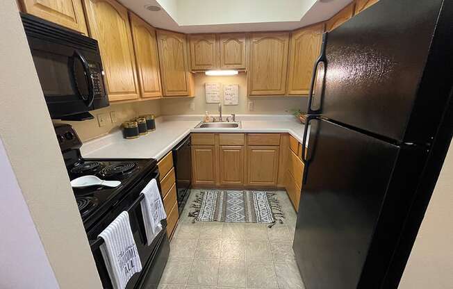 a kitchen with black appliances and wooden cabinets