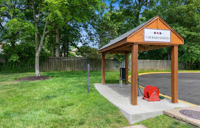 A car wash station with a wooden roof and a sign on it.
