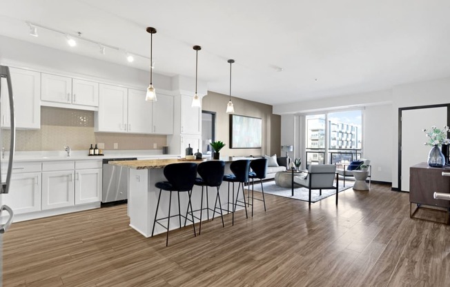 an open kitchen and living room with an island and bar stools